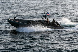 U.S. forces patrol the Arabian Sea near M/V Touska, April 20, as the Iranian-flagged vessel's container cargo is searched after U.S. Marines boarded and seized the ship when it attempted to violate the U.S. naval blockade